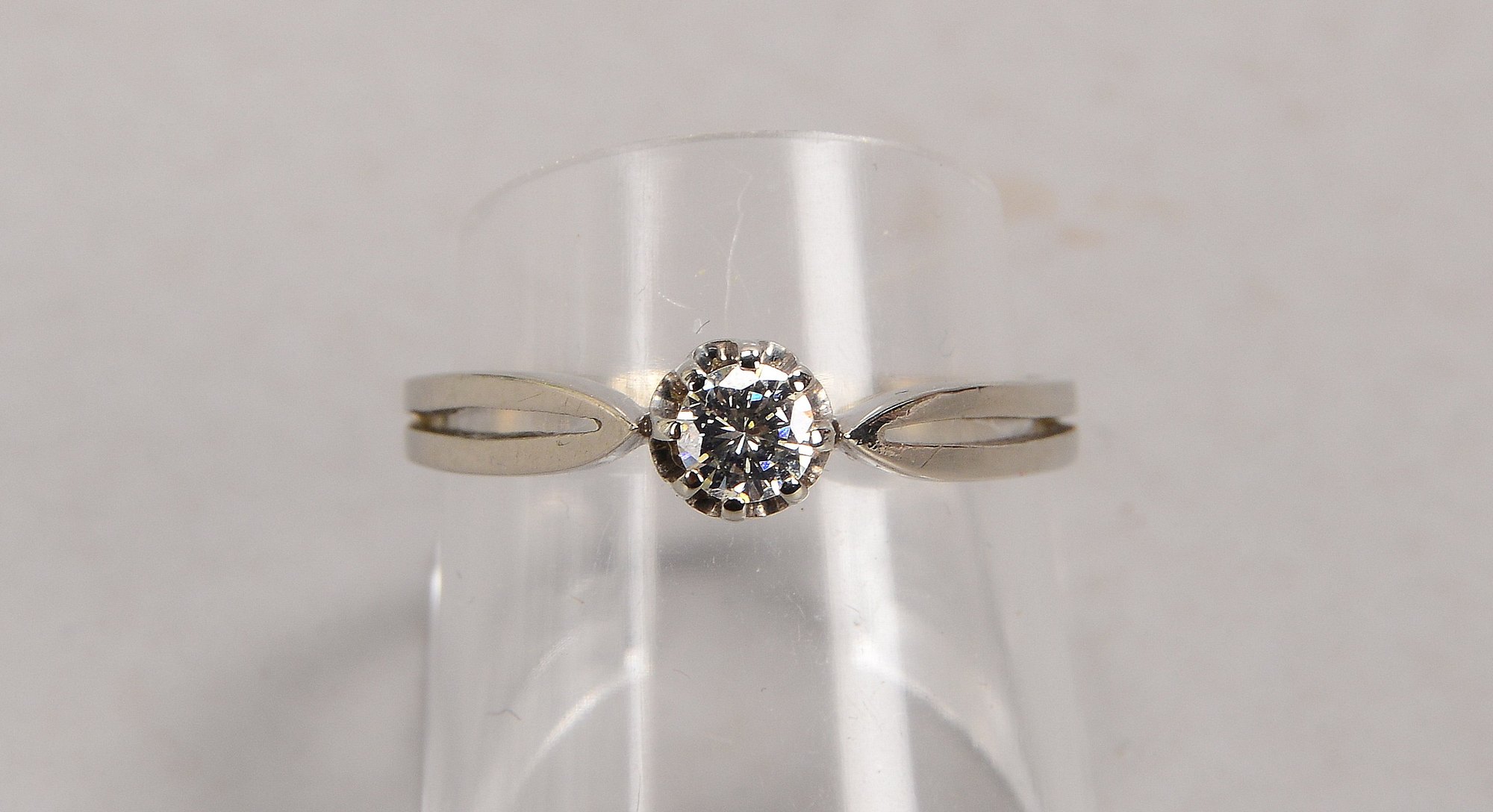 Ring, 585 WG (gestempelt), besetzt mit einzelnem Brillant von ca. 0,20 ct, getöntes Weiß - Weiß, Vsi