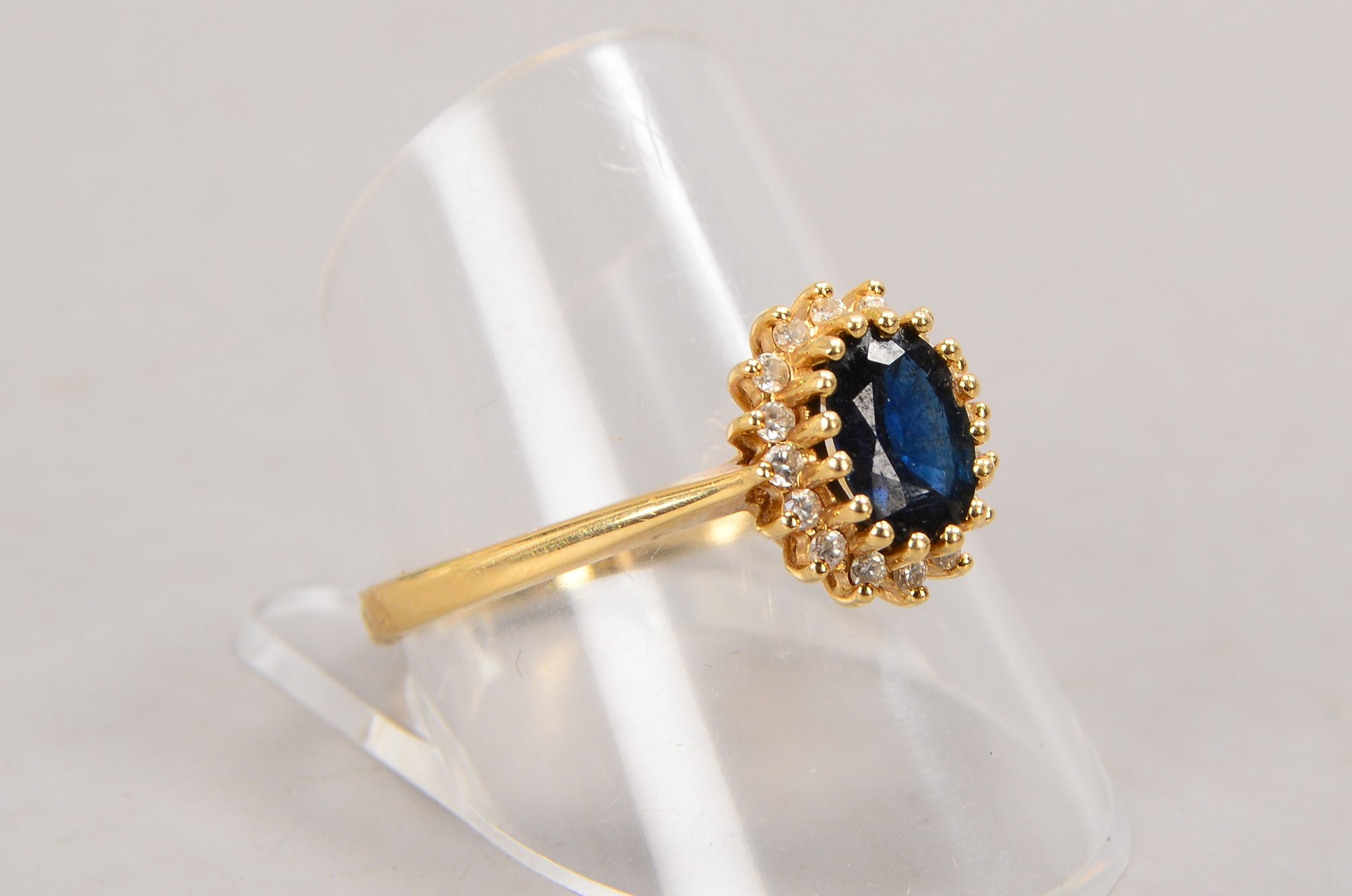 Ring, 585 GG (gestempelt), besetzt mit einzelnem Saphir, mit einer Entourage aus Brillanten; RG 62