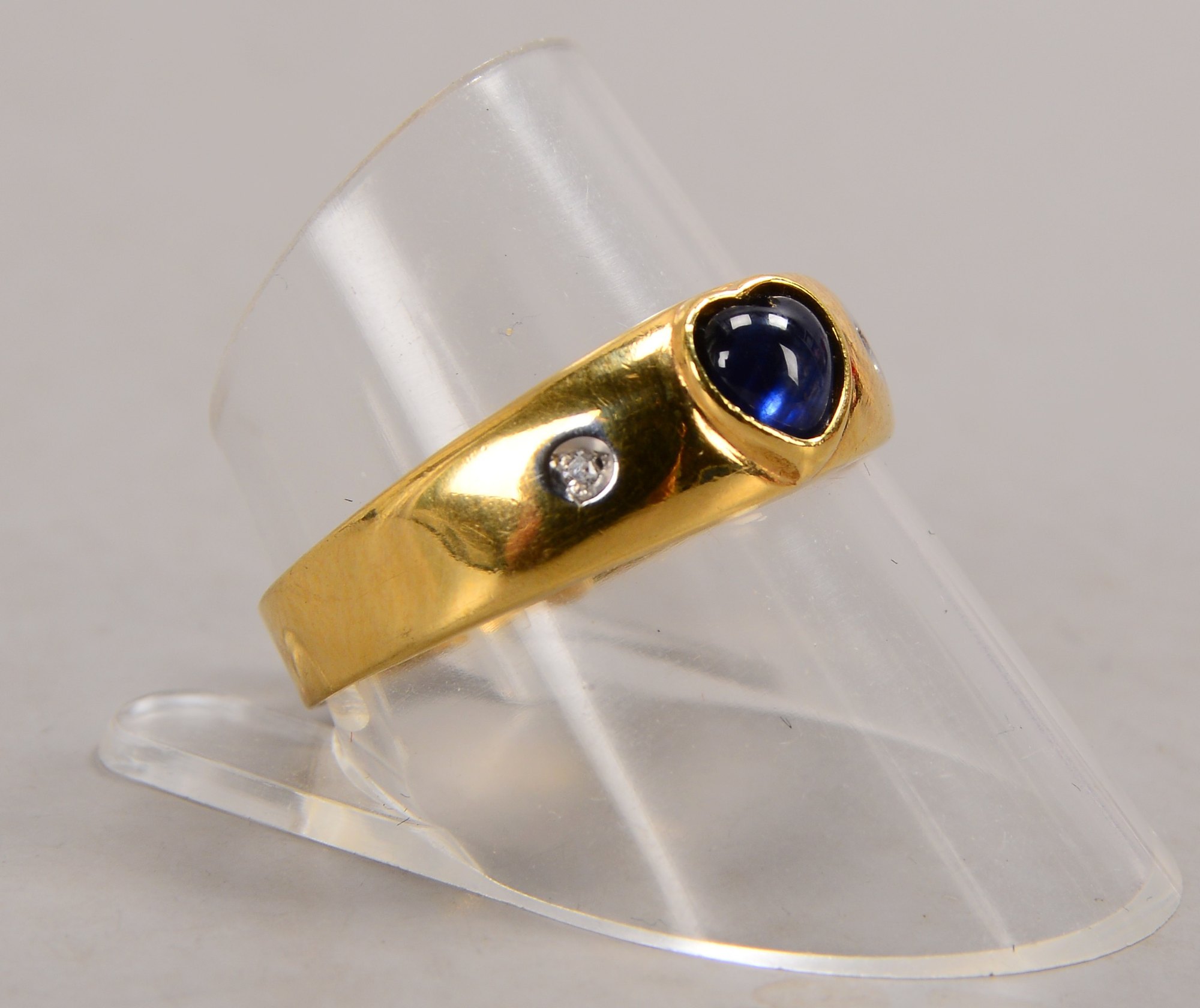 Ring, 333 GG (gestempelt), besetzt mit einzelnem Saphir, im Cabochonschliff, und 2x kl. Brillanten