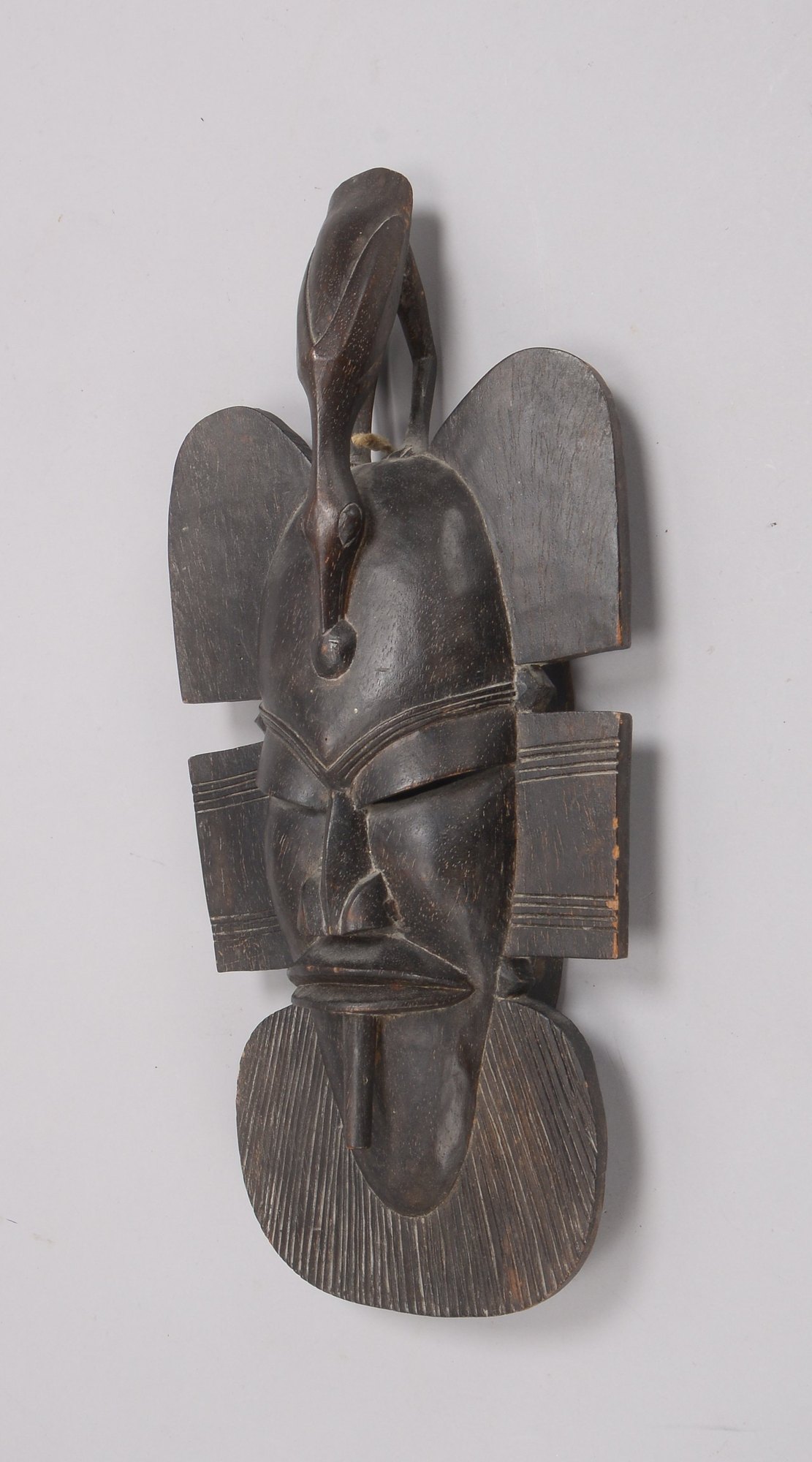Ritualmaske (wohl Benin/Afrika), Holz handgeschnitzt, mit figürlicher Bekrönung (Vogelmotiv)