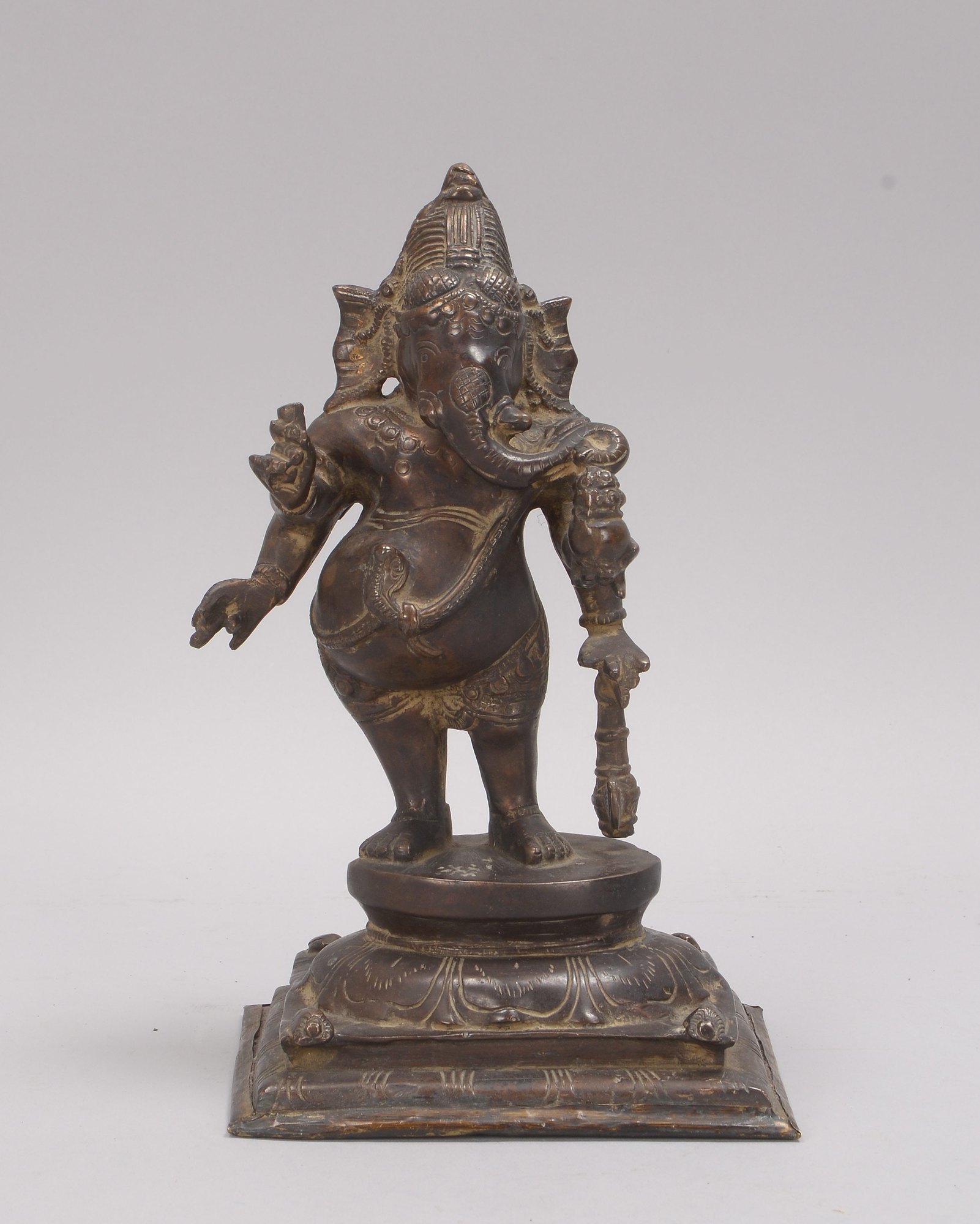 Bronzeskulptur (Indien), 'Ganesha' (Darstellung mit Attributen in den Händen), Figur mit Bodenplatte