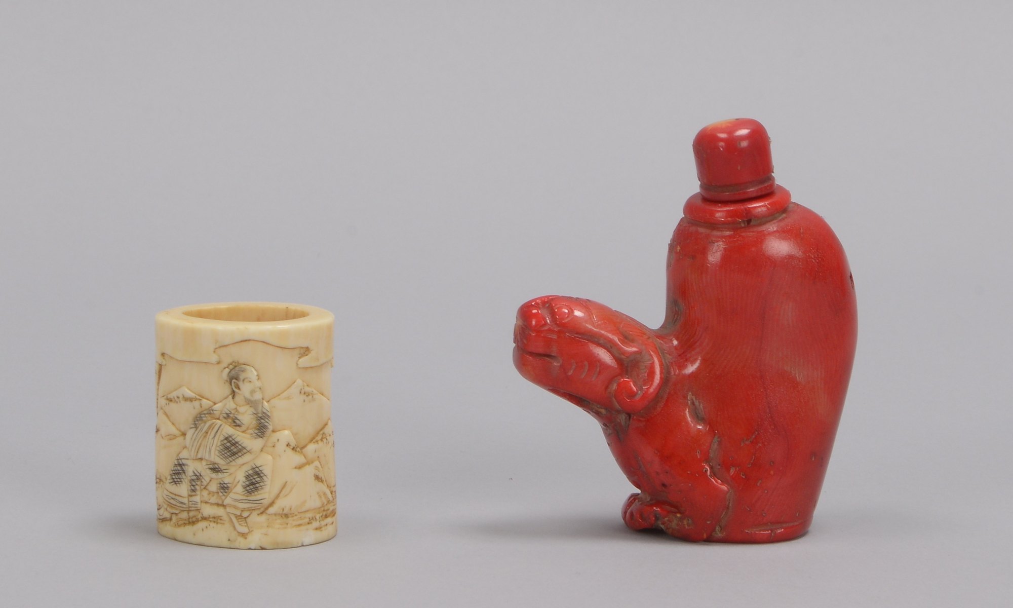 2 Asiatika-Sammlerstücke: figürliche Snuff Bottle, Koralle, Höhe 6,8 cm; und Kimono-Gürtelring, Bein