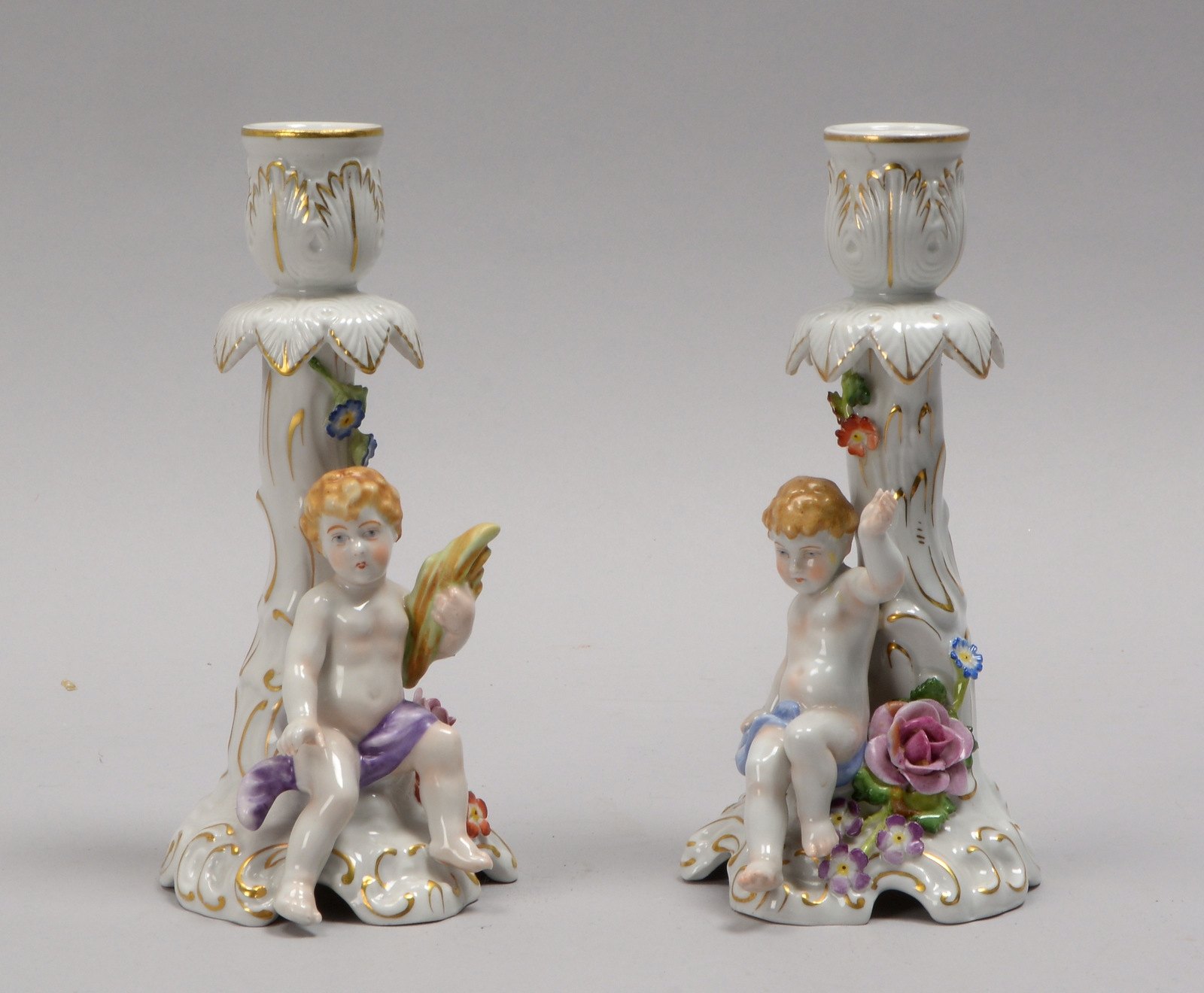 Schierholz, Paar Porzellan-Kerzenleuchter, plast. Figur 'Sitzender Putto'