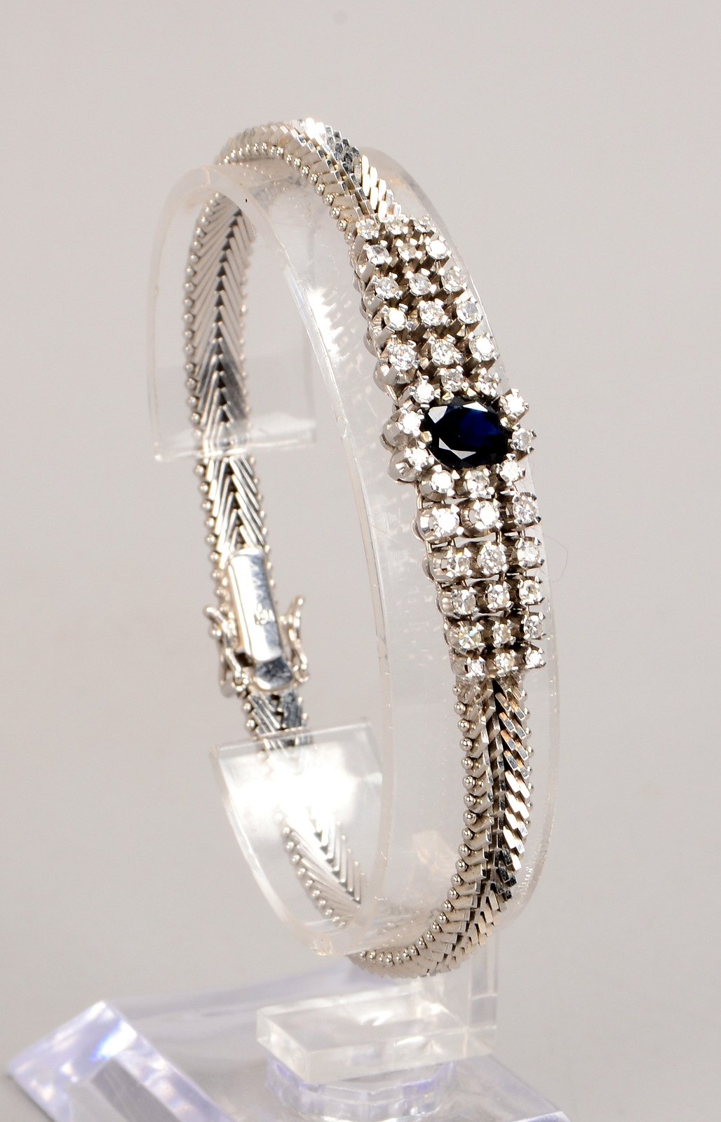 Armband, 750 WG (gestempelt), mit ovalem Saphir und 40x Diamanten/0,78 ct