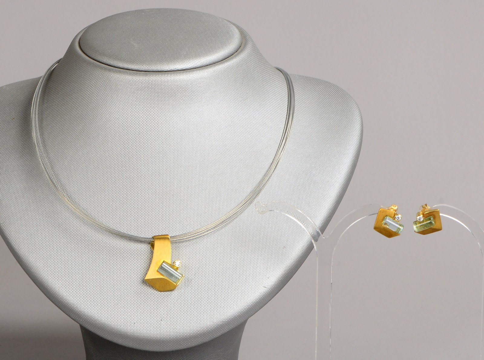 Schmuckset, 2-tlg., 333 GG, mit Smaragden/Zirkonen(?): Collier/Ohrstecker