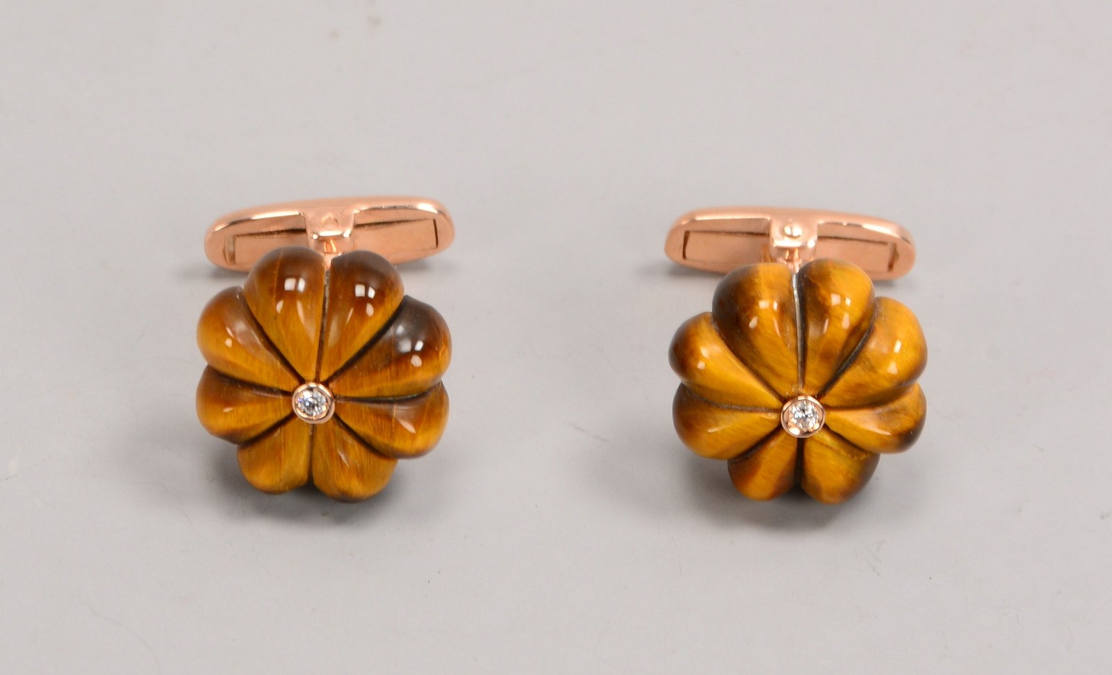 Paar Manschettenknöpfe, 9 kt Gold, mit Tigerauge und kl. Diamanten; Ø 14 mm
