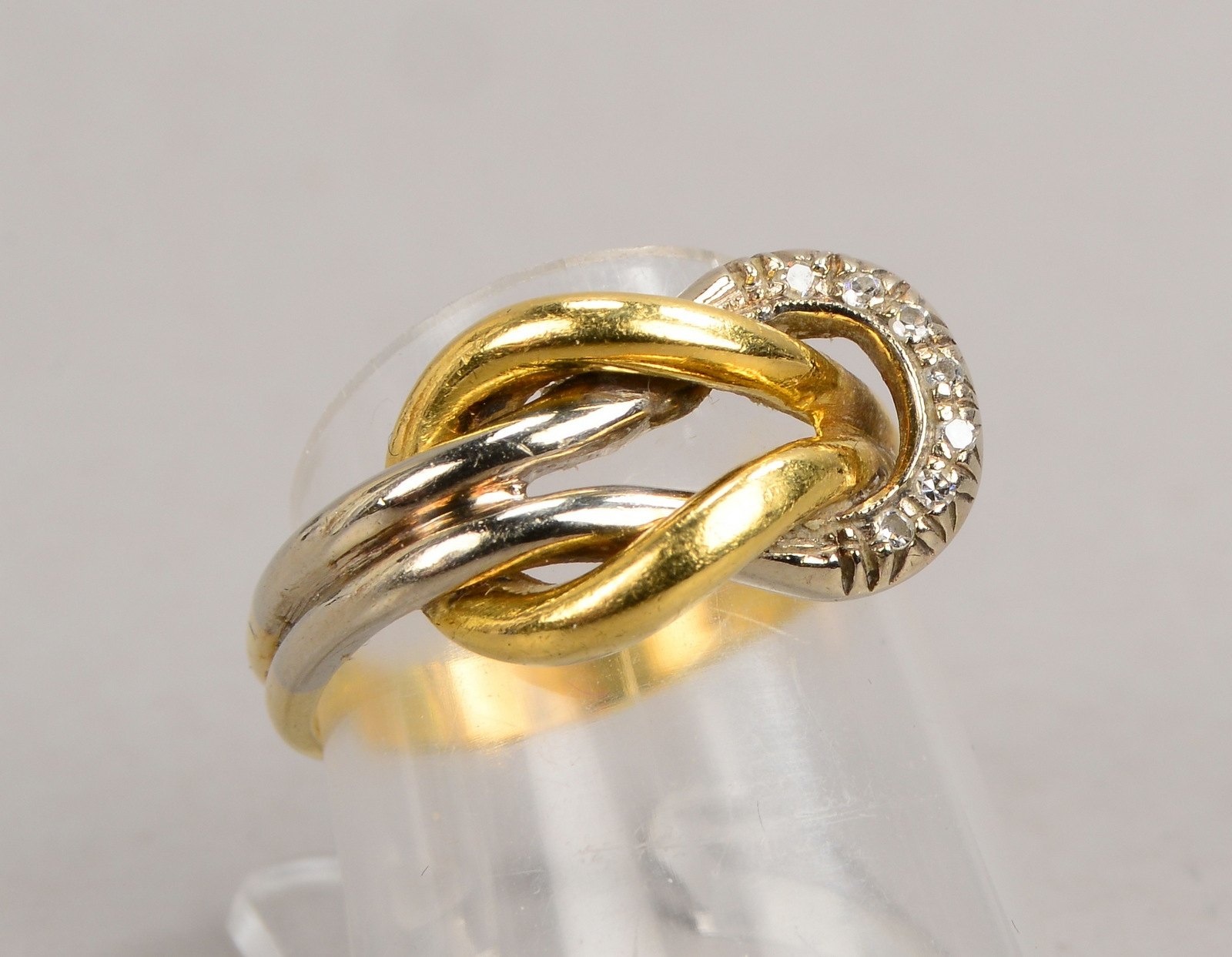 Ring, 750 WG/GG (gest.), Kreuzknotenform, mit 7x kl. Diamanten
