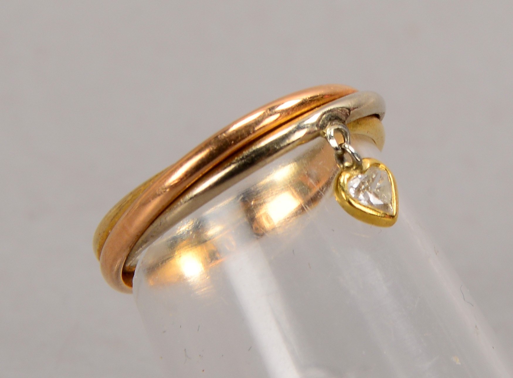 Ring, 750 Gold/Tricolor, aus 3x ineinander verschlungenen Ringen, besetzt mit einzelnem kleinem Diam