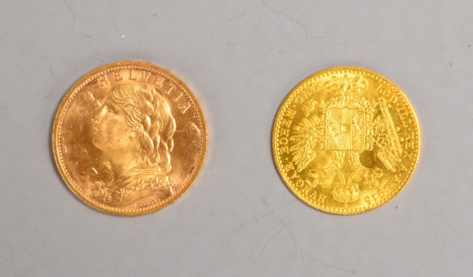 2 Goldmünzen: '20 Franken', 900 Gold, Gew. 6,45 g; und '1 Dukat', 986 Gold, Gew. 3,49 g