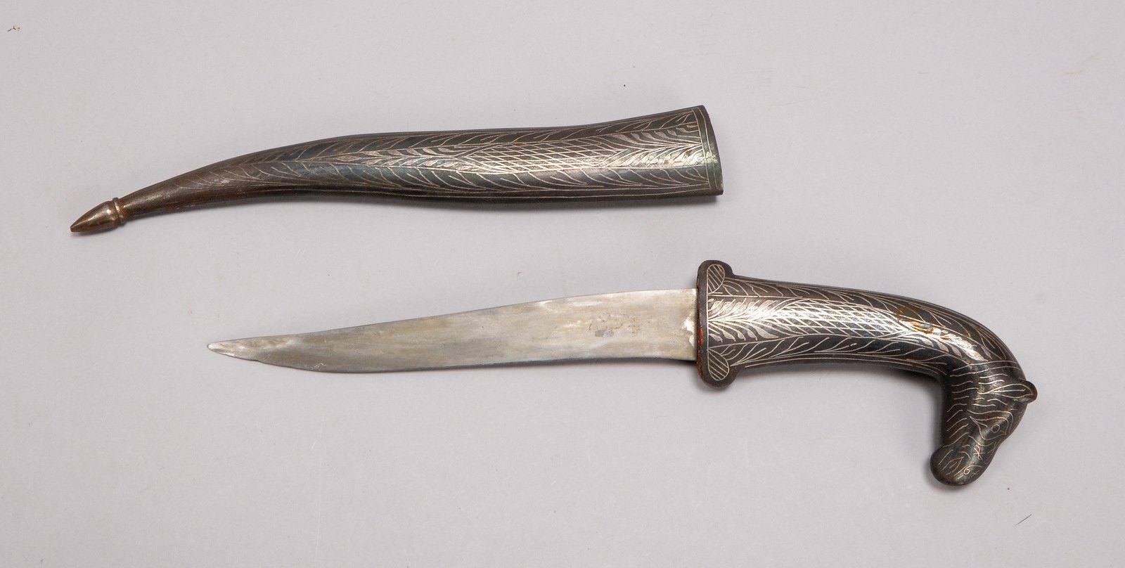 Krummdolch (Indien), figürl. Griff und Scheide mit Metall-Ummantelung/Silberverz.