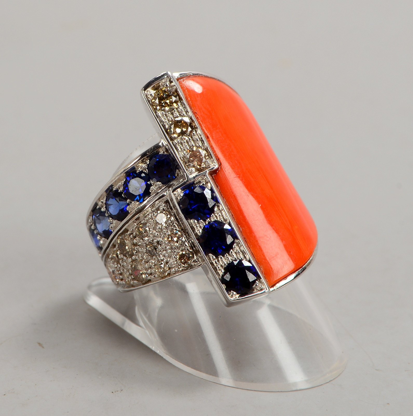 Ring, 585 WG (gest.), mit Koralle/2,70 g, Saphiren/zus. 1,77 ct, und Brill./zus. 0,80 ct