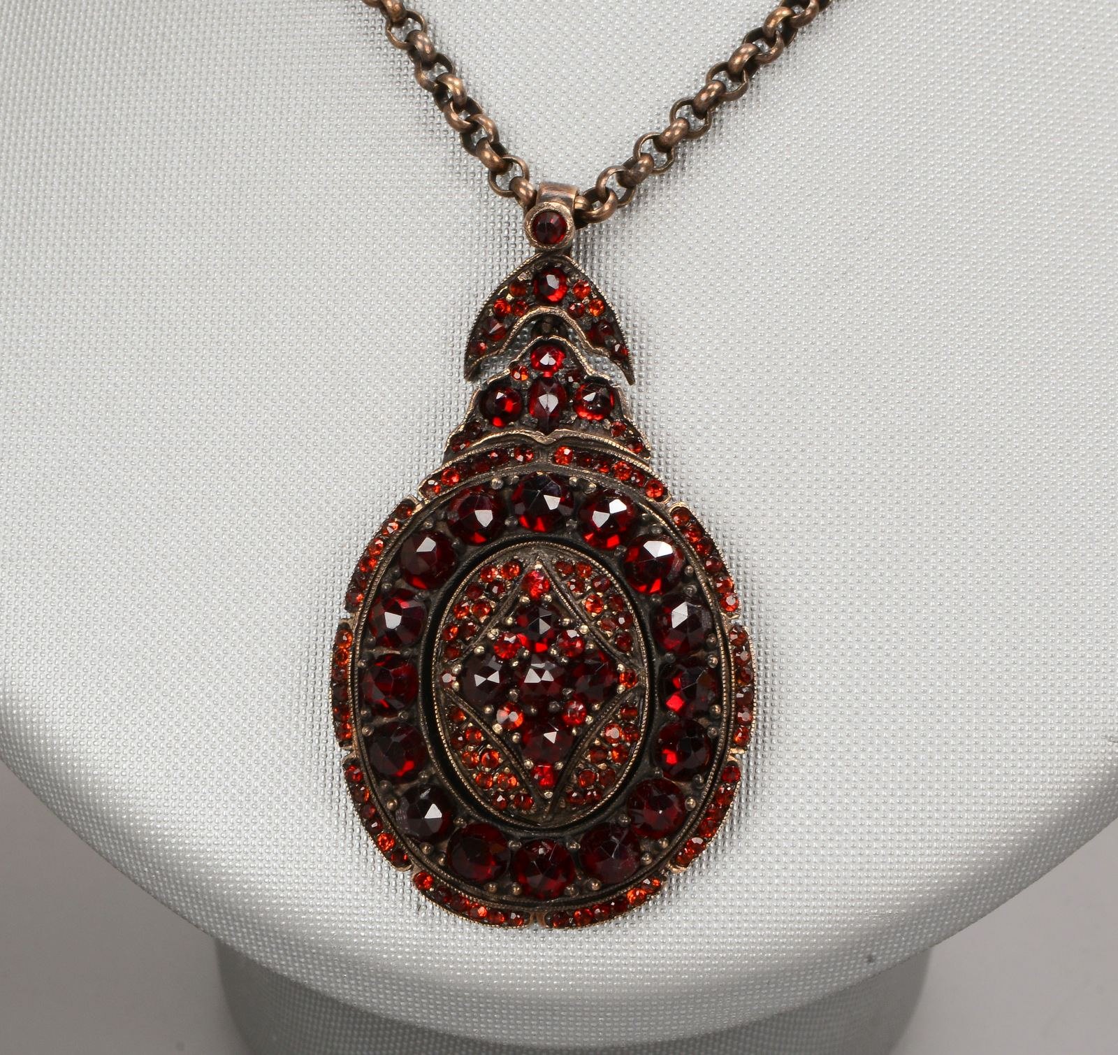 Medaillon-Anhänger, Strass-/Granatbesatz, Länge 4,5 cm; an Silberkette, Länge 58 cm
