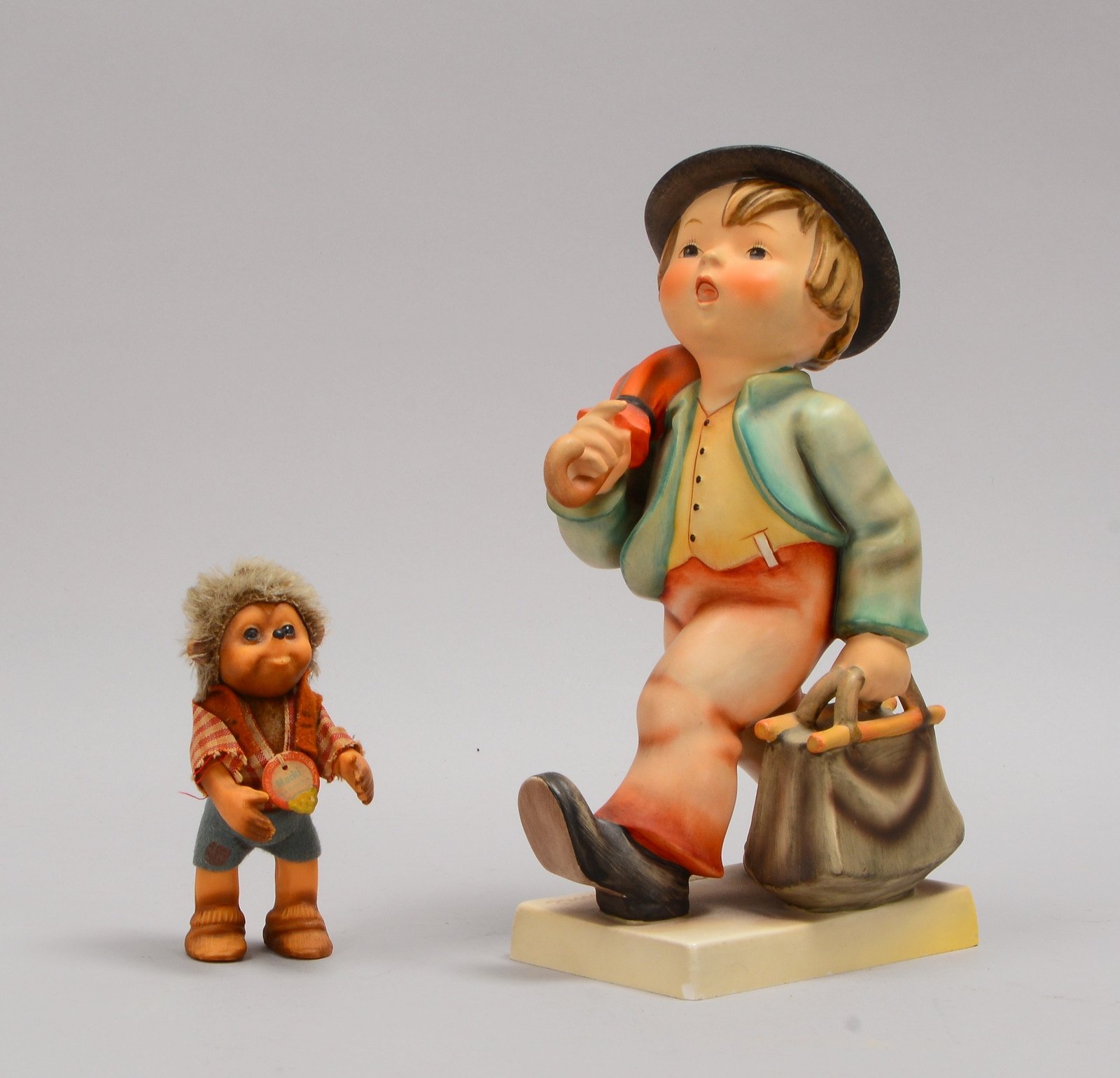 2 Sammlerfiguren: 1x Keramikfigur, 'Wanderknabe', und 1 kleine Steiff-Figur 'Mecki'