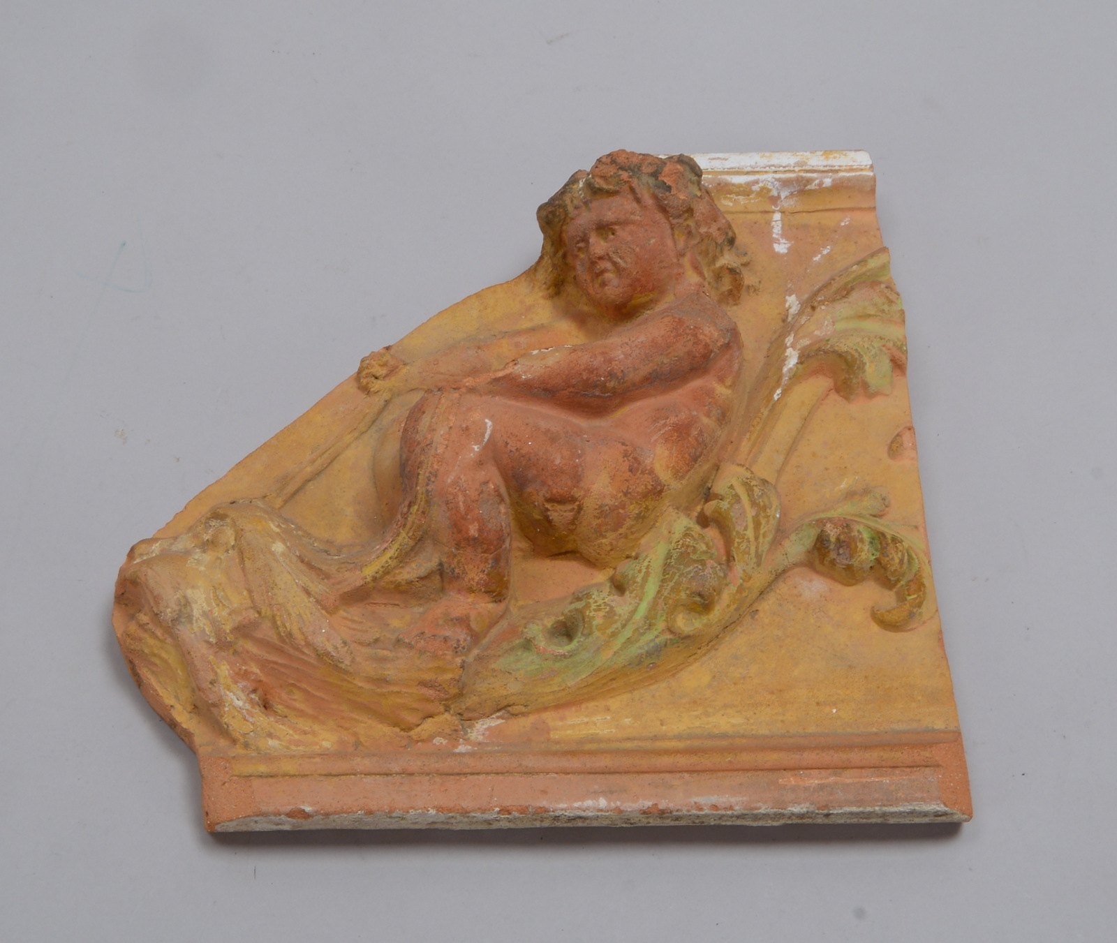 Halbfigürl. Fliesenfragment, 'Knabe auf Löwenkopf', Terrakotta/Reste farb. Staffierung