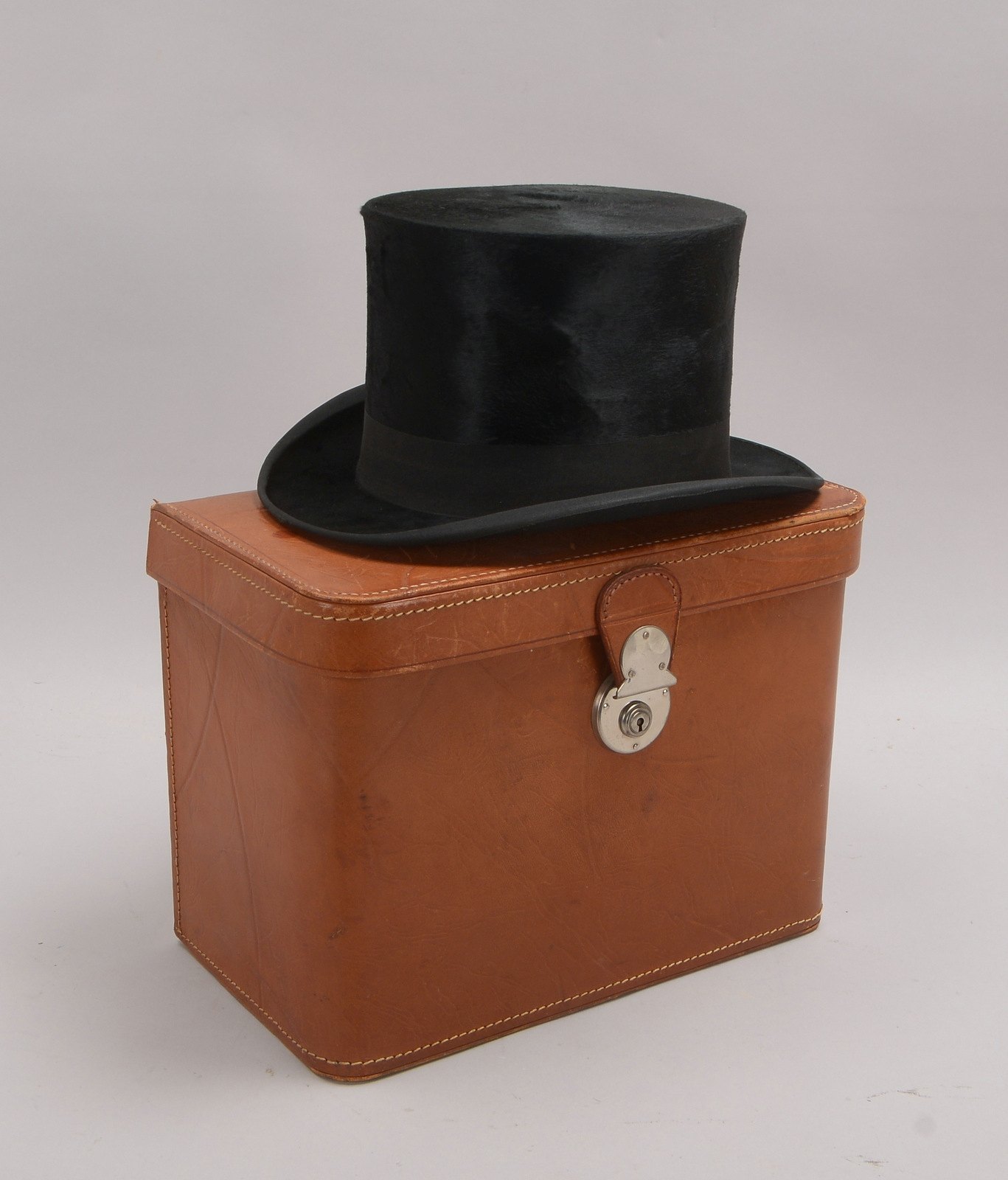 Orig. Chapeau Claque, im Leder-Hutkoffer, bez. 'P. Stark', 'F.H.'; Höhe Hut 15 cm