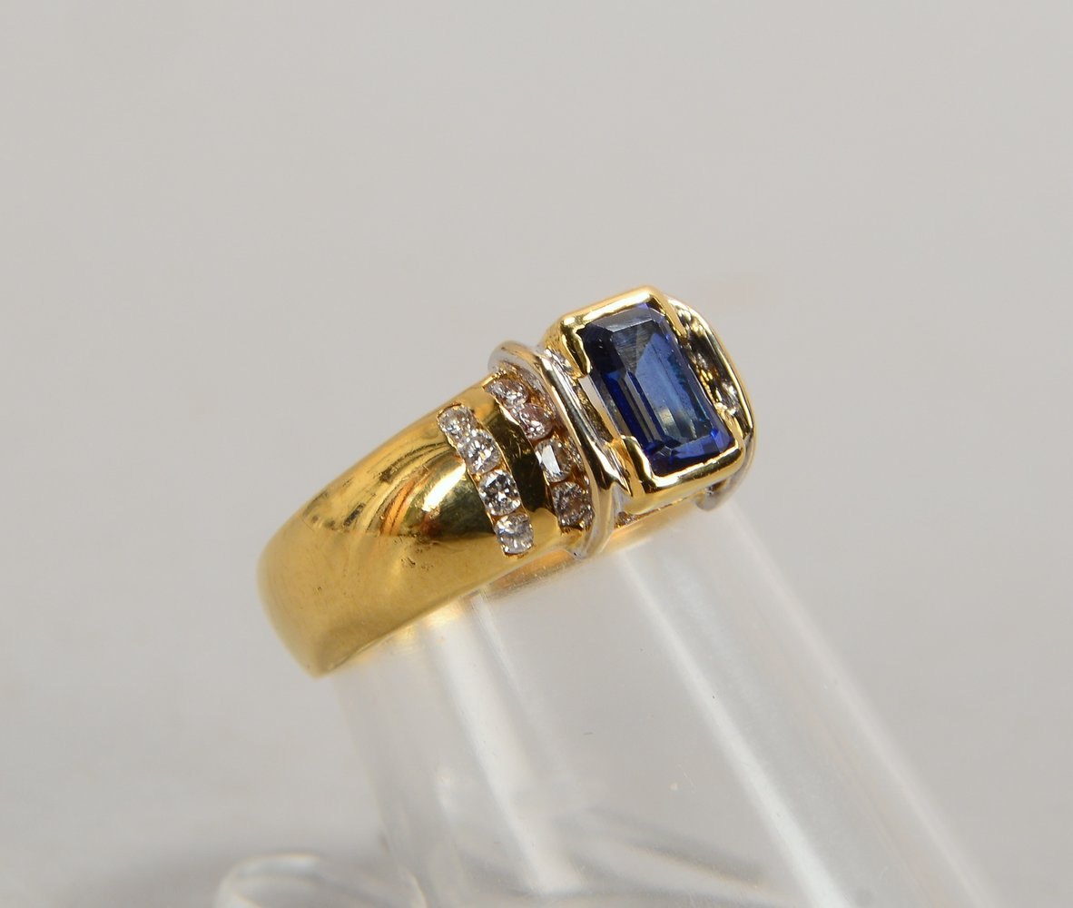 Ring, 750 GG (gest.), mit einzelnem Saphir im Smaragdschliff, und mit 18x kl. Brill.