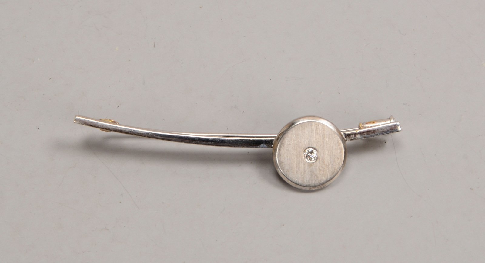 Brosche, 750 WG (gest.), besetzt mit einzelnem kl. Brill. von ca. 0,05 ct; Gew. 10,50 g