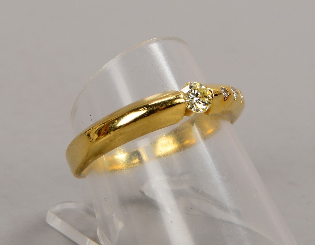 Ring, 585 GG (gest.), mit Brill. von ca. 0,24 ct, und 3x kl. Begleitdiamanten; Gew. 3,90 g