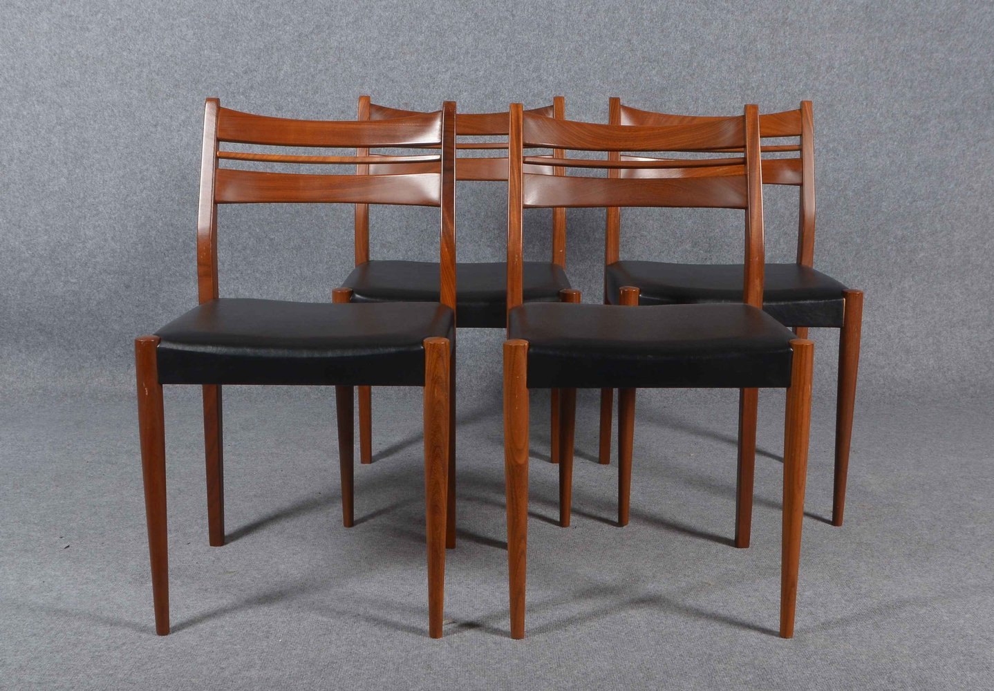 4 Stühle, Teakholz, mit schwarzem Kunstleder-Bezug, guter Zust.; Lehnhöhe 78 cm