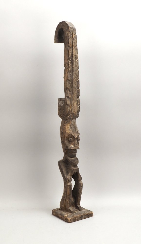 Hölzerne Stele, mit sitzender Figur; Höhe 100 cm (Sockel mit Trocknungsriss)