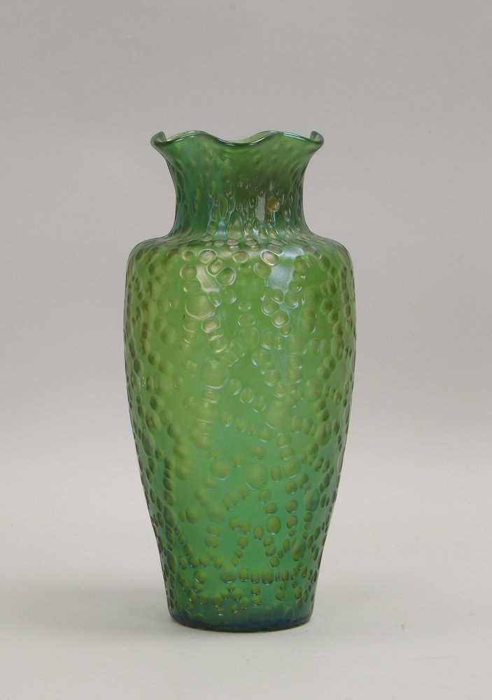 Glasvase, grünes leicht irisierendes Glas mit kraterf. Oberfläche, gewellter Rand, mit Abriss