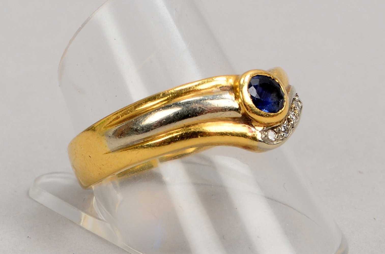 Ring, 750 GG/WG (gest.), besetzt mit Saphir und 7x kl. Diam.; RG 62, Gew. 5,20 g