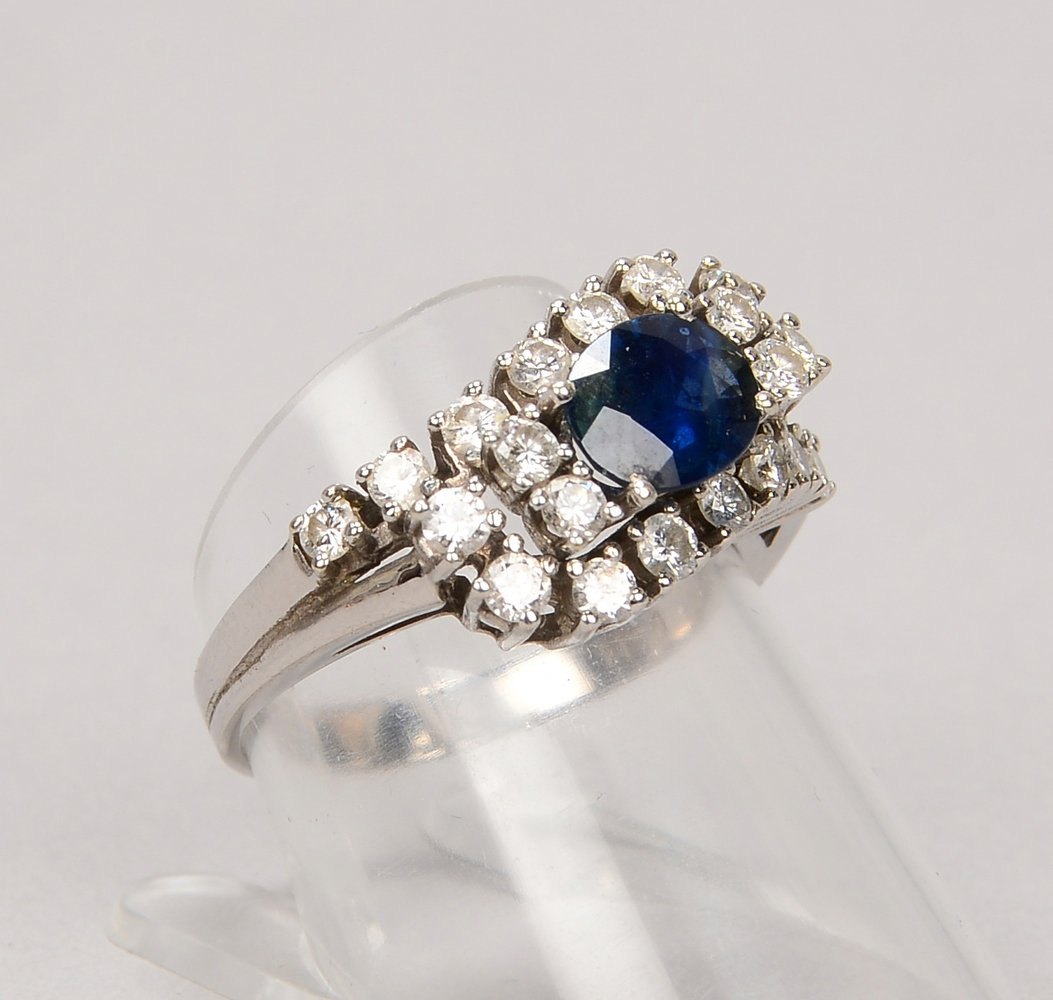 Ring, 585 WG (gest.), besetzt mit ovalem Saphir und 18x kl. Brill./zus. ca. 0,84 ct; RG 57