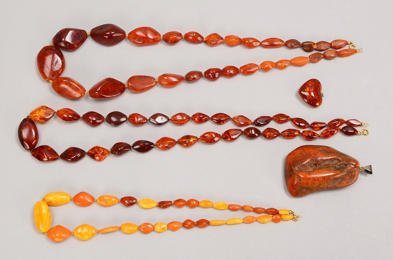 Bernsteinschmuck: 3x Halsketten, dkl.-braun/honigf.; und 2x Anhänger, gr./kl. ('Herz'): Gew. 66 g