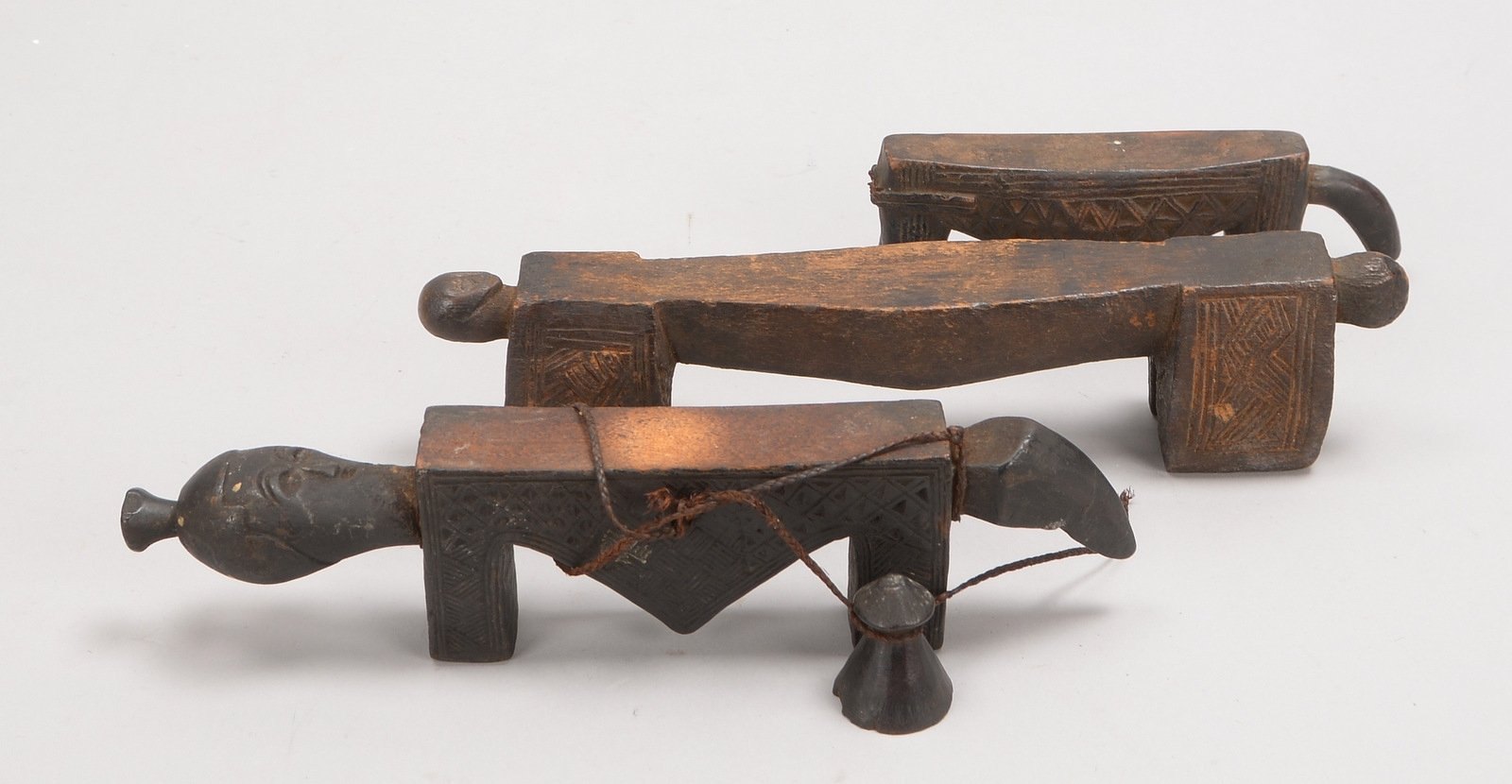 3 Kopfstützen, Holz, versch. Ausf., stilisierte figürl. Gestaltung; Länge 17 cm - 29 cm