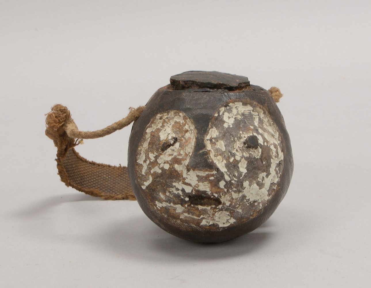 Kl. Musikinstrument, figürl. ('Männerkopf'), Kalebassenform, mit Restfassung; Ø 10 cm