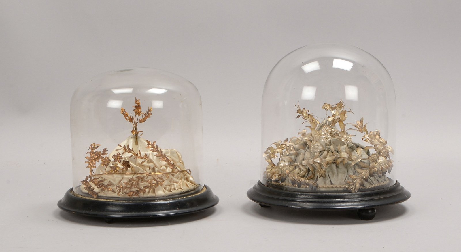 2 Glasstürze, alt, jew. auf Holzstand - mit Vintage-Brautschmuck; Höhe 17 cm, und Höhe 20 cm