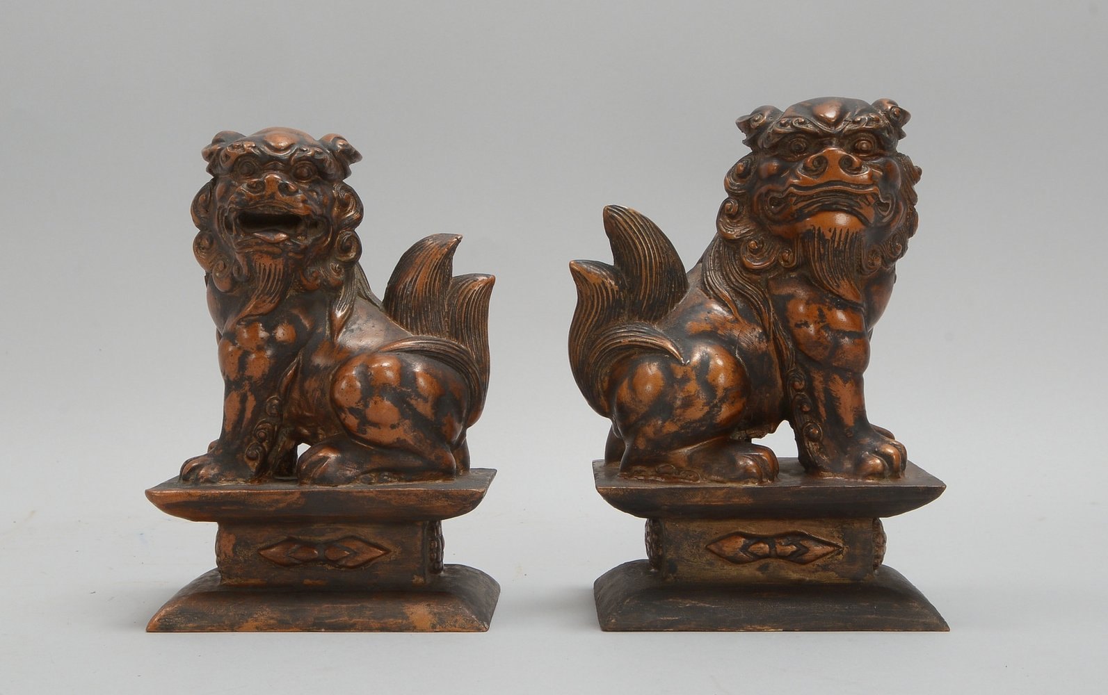 Paar Wächterfiguren/Beisteller, 'Fu-Hunde', Holz bronziert, auf Postament; Höhe 18 cm