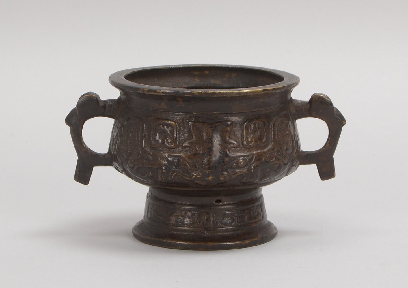 Bronzegefäß, Reliefdekor im archaischen Stil, 2x Handhaben, im Boden gemarkt; Ø 10 cm