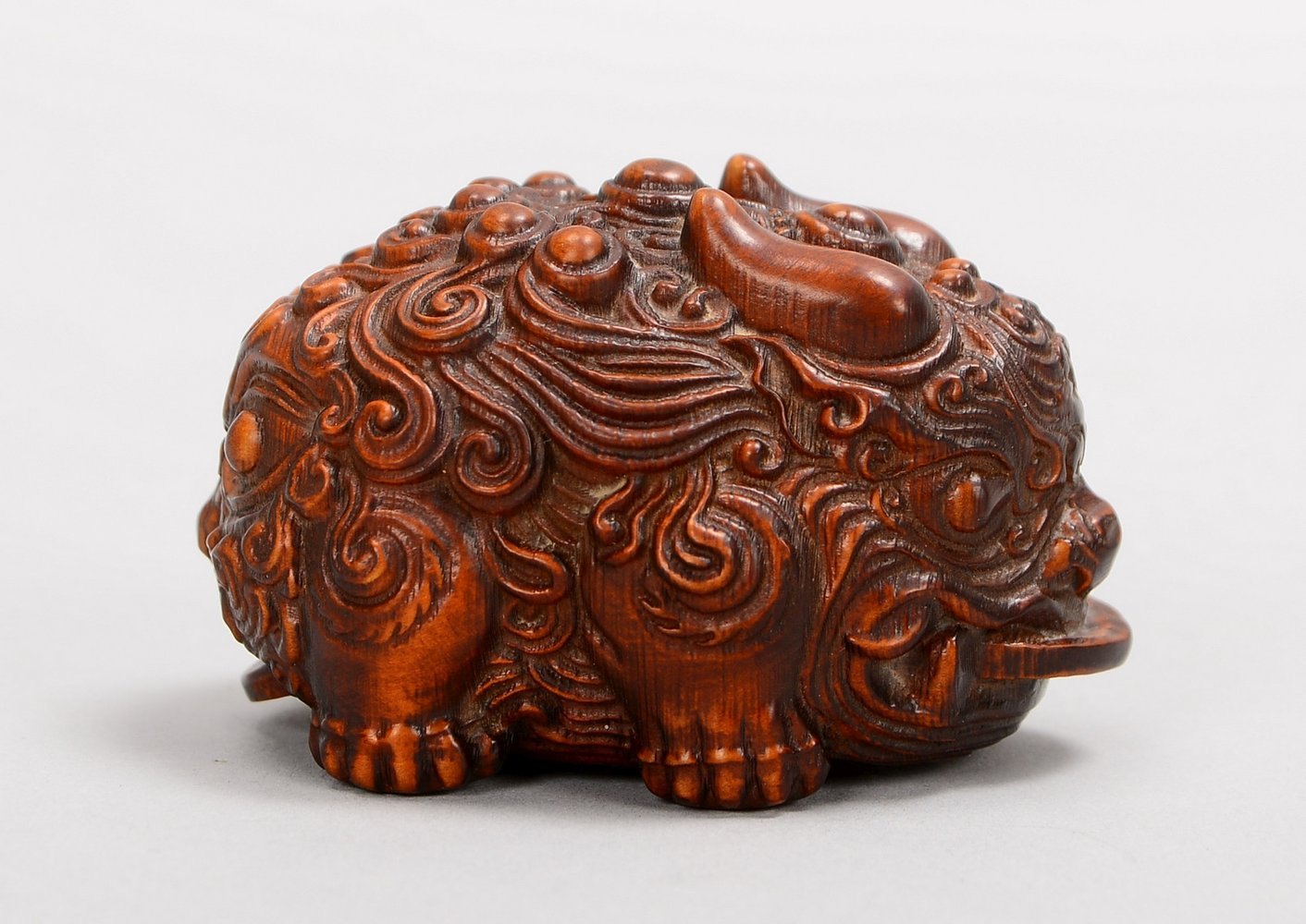 Netsuke (China), plastisch geschnitzte Holzfigur, 'Fu-Hund'; Länge 6 cm