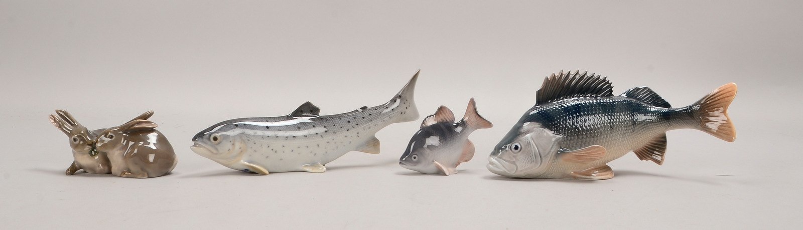 4 Porz.-Figuren: 3x Fischfiguren, versch. Ausf., sowie 1 Figurengruppe 'Hasenpaar'