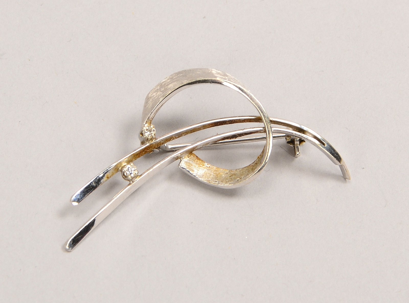 Brosche, 750 WG (gest.), besetzt mit 2x kl. Brill.; Länge 4,5 cm, Gew. 3,20 g