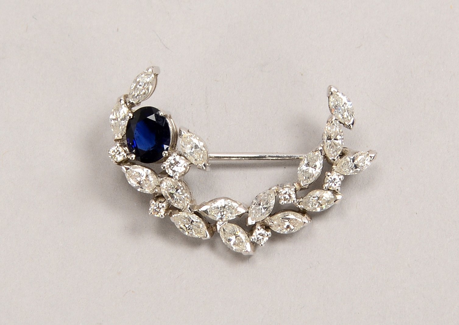 Brosche, 750 WG (gepr.), mit Saphir und 21x Diam. im Marquise-/Brillantschliff; Gew. 3,60 g