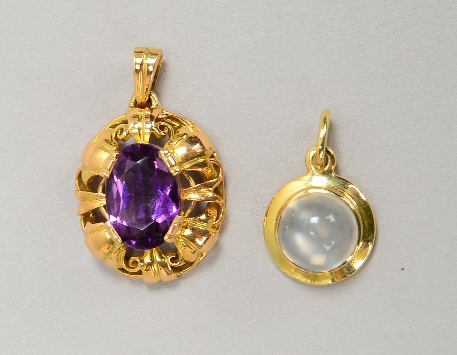 2 Anhänger, 585 GG (gest.): 1x mit fac. ovalem Amethyst, 1x mit Mondstein-Cabochon