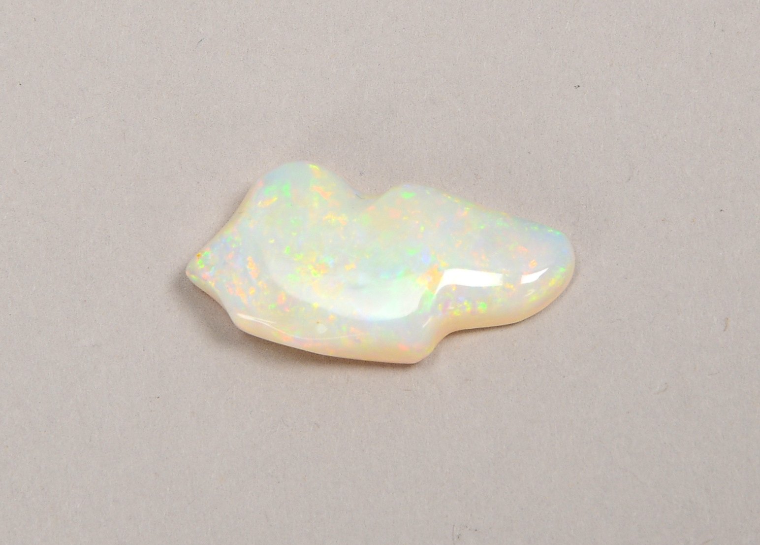 Vollopal, unregelmäßig geformter Stein im Cabochonschliff; Länge 2,5 cm, Gew. 2 g