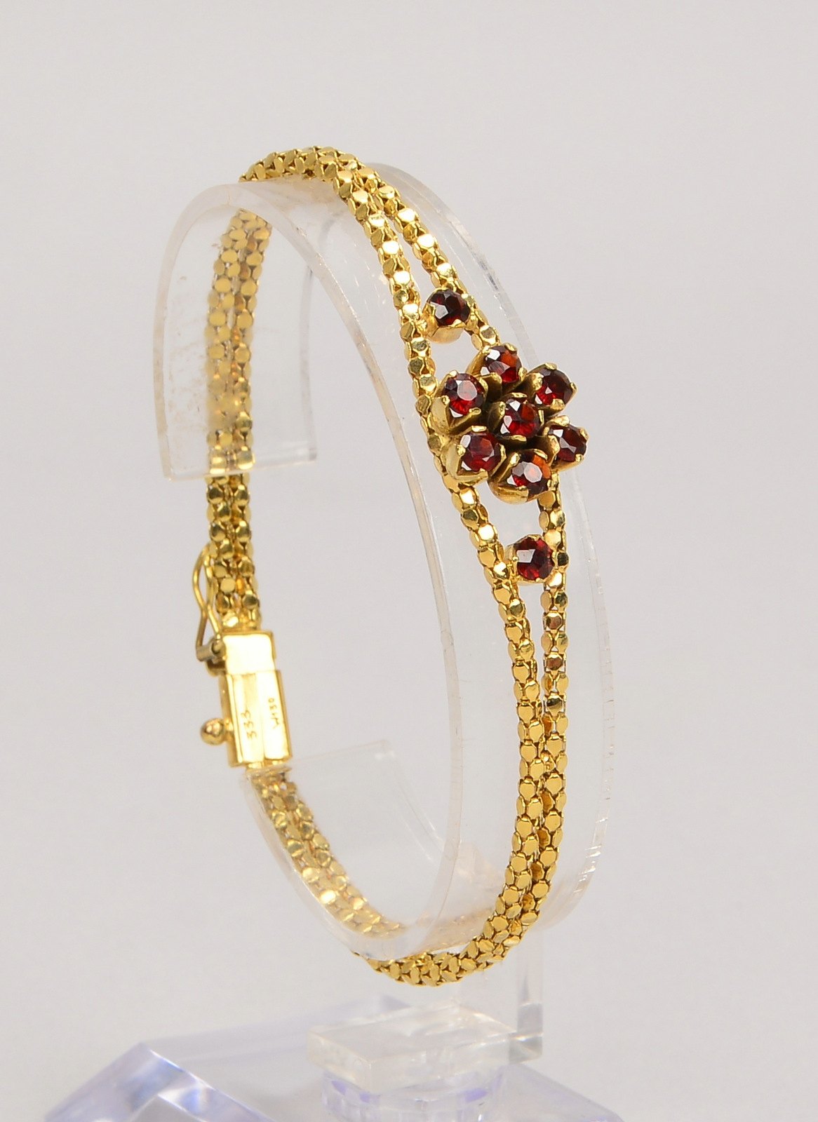 Armband, 333 GG (gest.), mit Granatbesatz, Steckschließe; Länge 18,5 cm, Gew. 7,20 g
