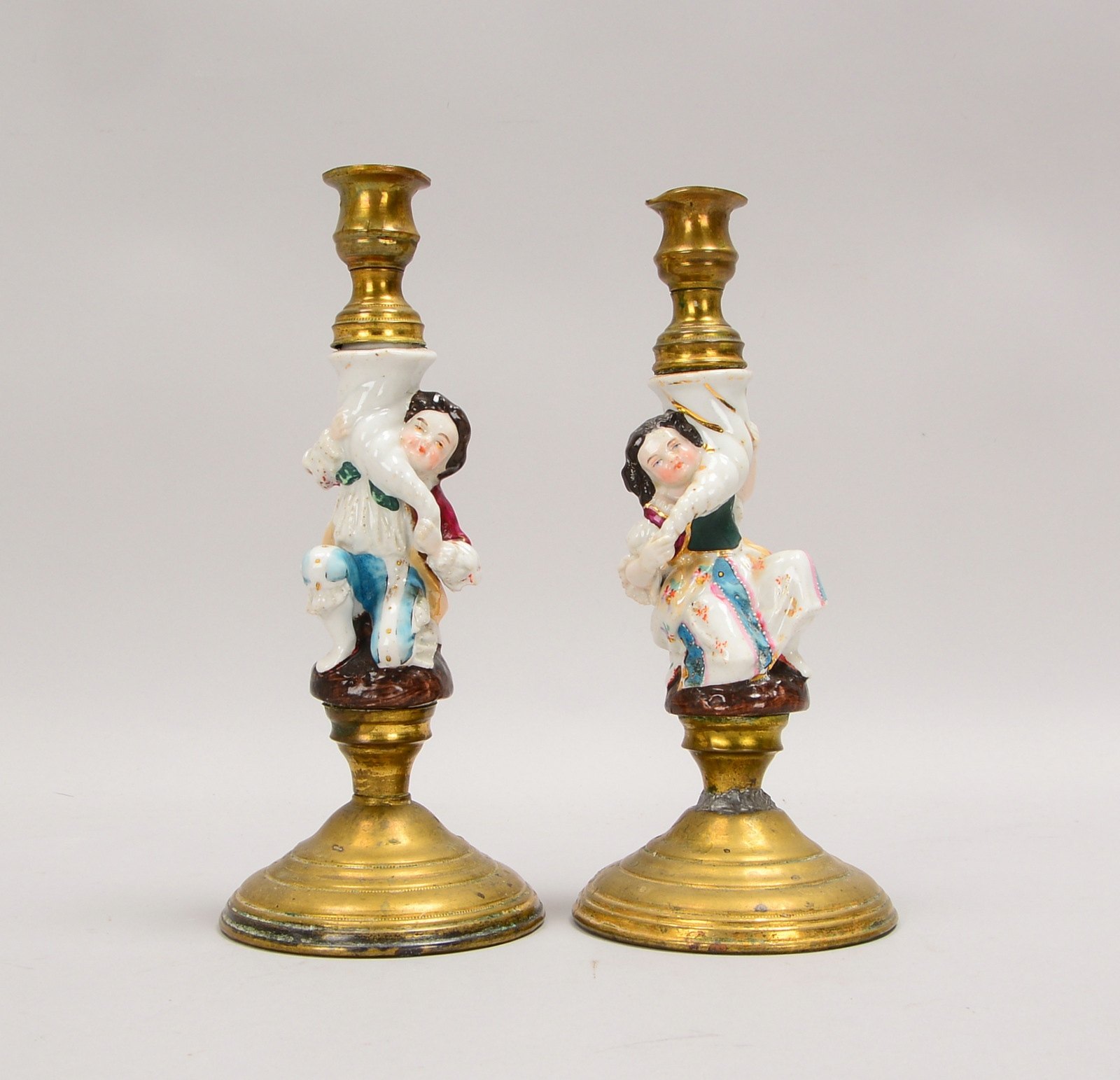 Paar antiker Kerzenleuchter, Messing, mit figürl. Porzellanschaft; Höhe 23 cm