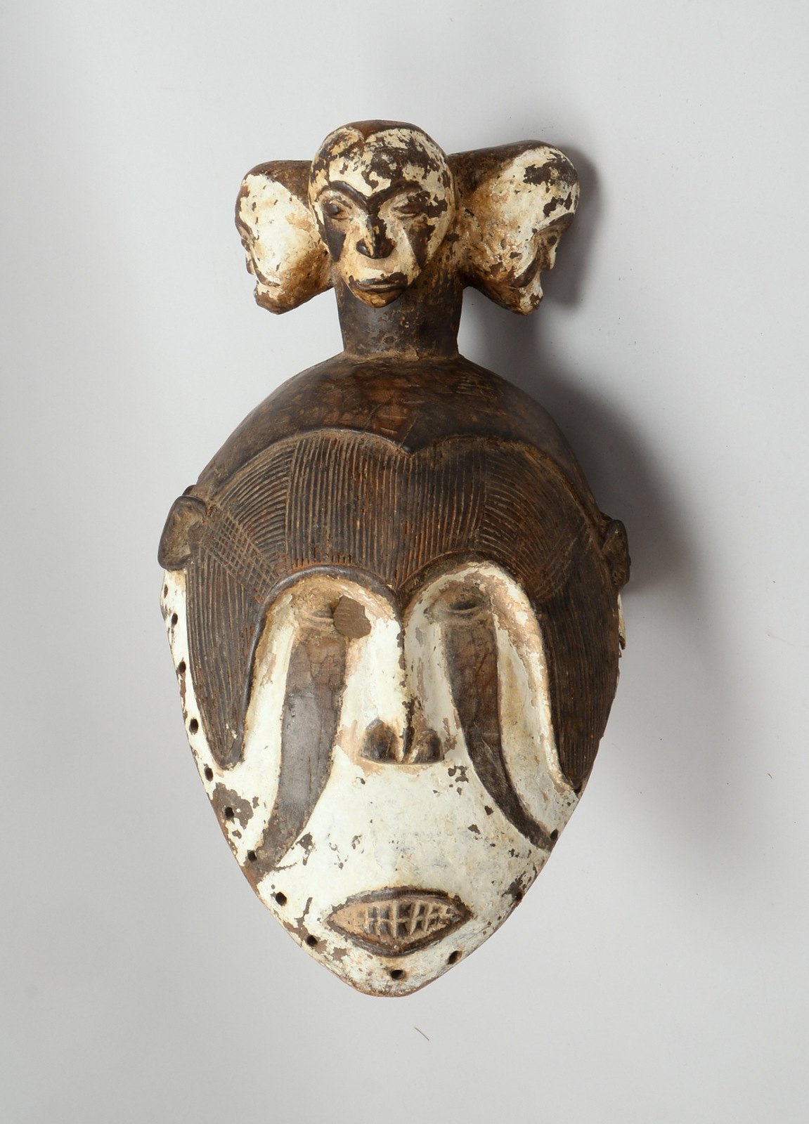 Tanzmaske (Igbo/Nigeria), Holz, janusköpfige Helmmaske, z.T. weiß gef.; Höhe 42 cm