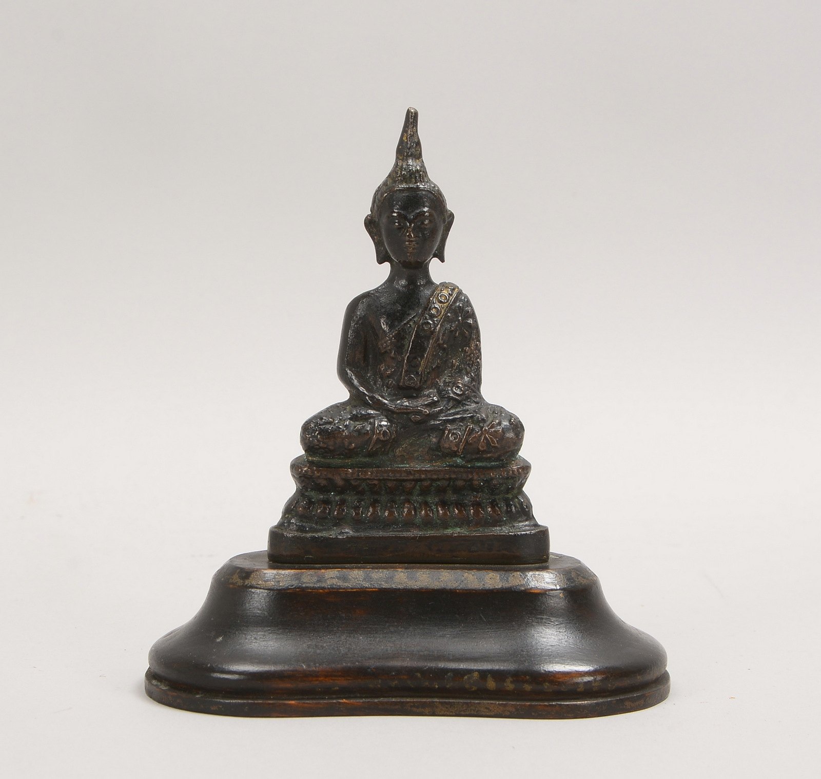 Bronzeskulptur, 'Sitzender Buddha', mit dkl. Patina, auf Holzsockel; Höhe 14 cm