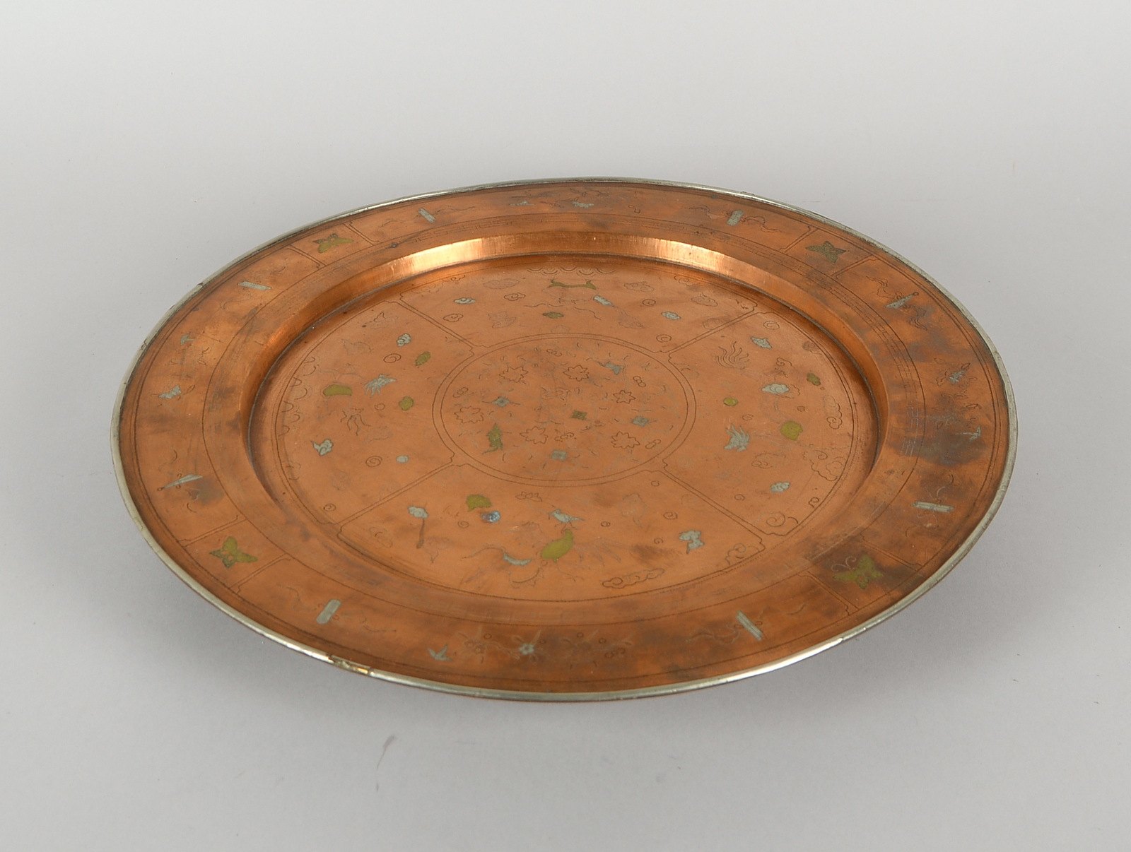 Kupferteller mit Silber-/Messingeinlagen und Gravuren, auf 3x grav. Füßen; Ø 40 cm