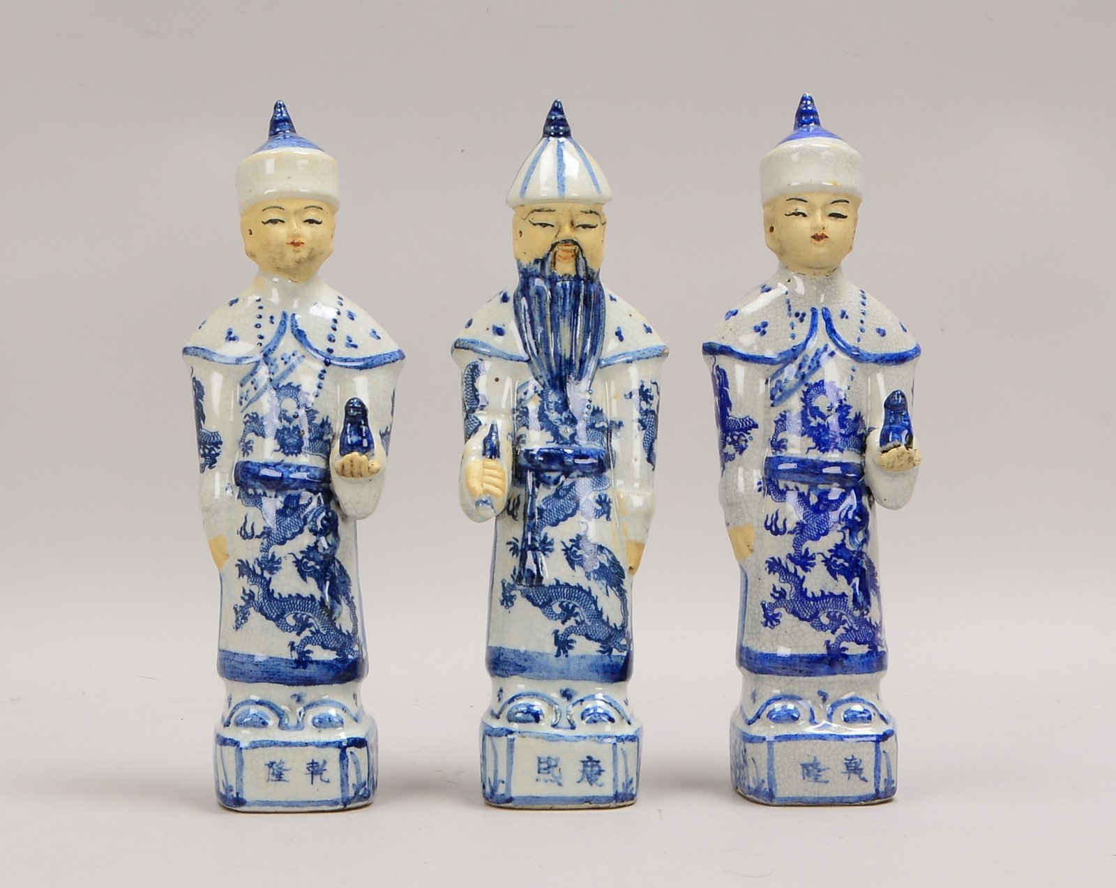 3 Porzellanfiguren, 'Männerfiguren', jeweils mit Handattribut, im Boden gest.