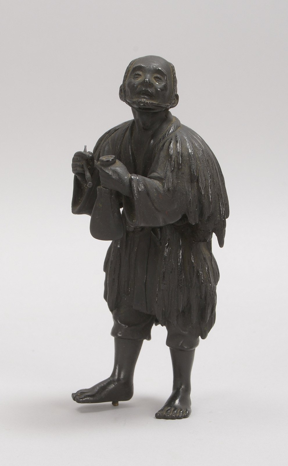 Bronzeskulptur, 'Mann mit Glocke', als Steckfigur, mit dunkler Patina; Höhe 16 cm
