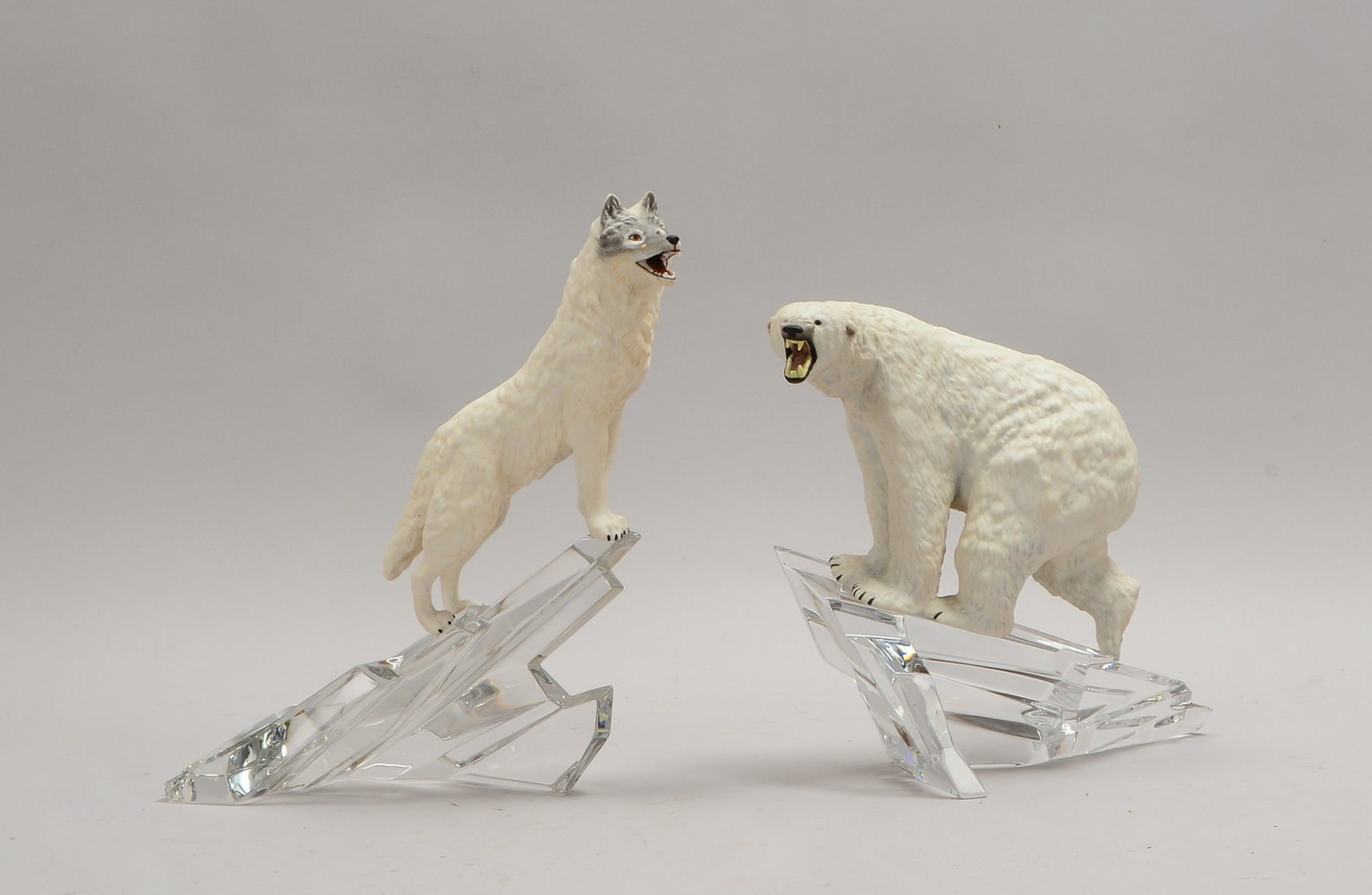 Franklin Mint, 2 Biskuitporz.-Figuren, auf Kristallglas-Sockel: 1x 'Eisbär', 1x 'Wolf'