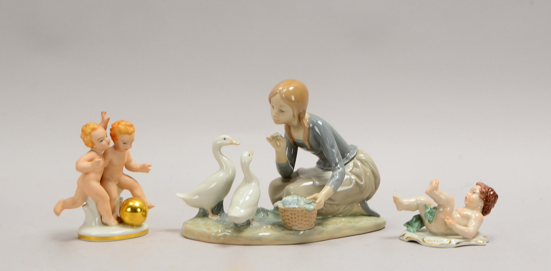 3 Porz-Figuren: 1x Lladro, 'Gänseliesel', 1x Kämmer, 'Putto', 1x Gerold & Co., 'Spielende Putti'