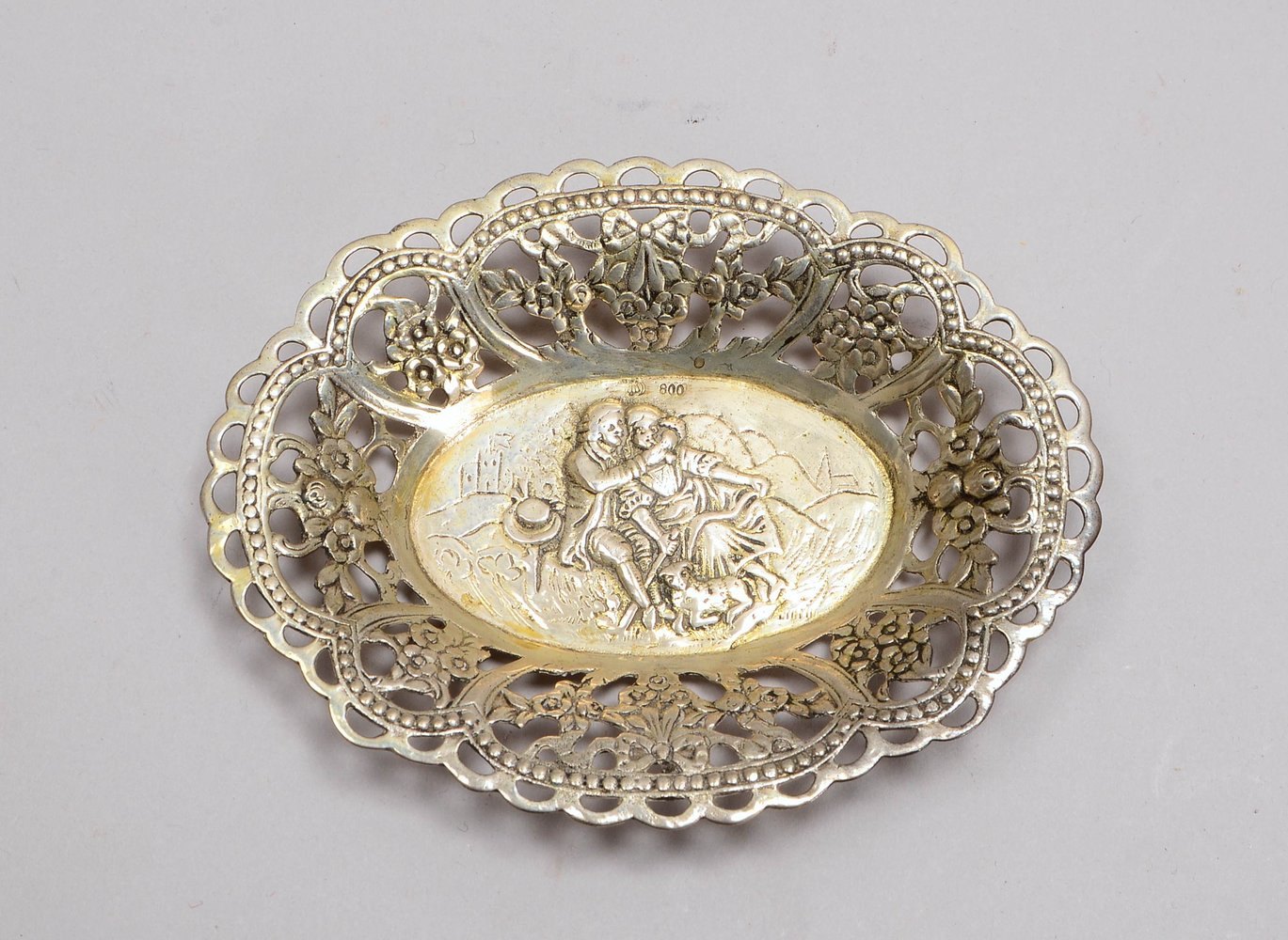 Barocke Schale, 800 Silber, durchbr. Rand, im Spiegel relief. 'Liebesszene'; Gew. 52 g