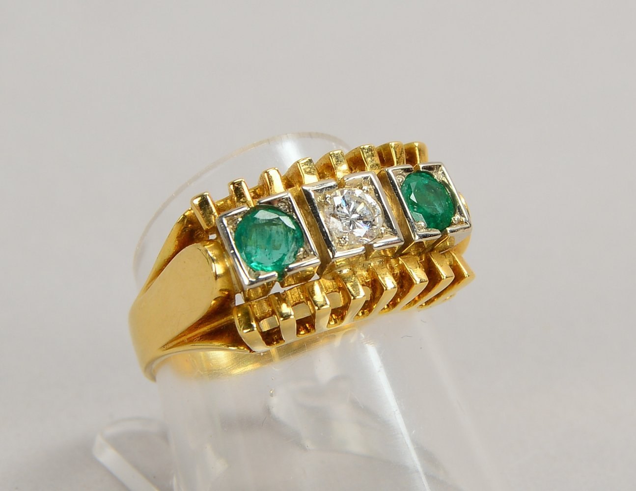 Ring, 750 GG/WG (gest.), mit Diam. von ca. 0,25 ct und 2x Smaragden/zus. 0,60 ct; Gew. 8,42 g